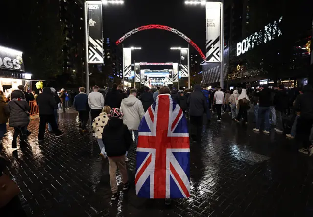 General view outside the stadium as a fan draped in the Union Jack flag w