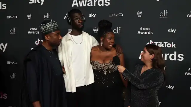 mother and son due Tola (in a long black gown) and Kevin (in a white t-shirt and shirt and black trousers) on the TikTok Awards red carpet