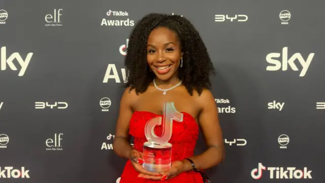 Joy Anokwuru holding her Rising Star award on the red carpet