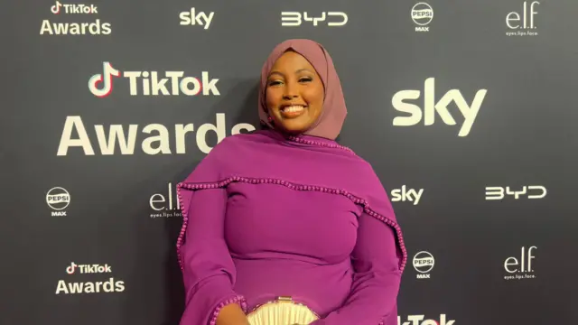 Jamilo stands and smiles for the camera