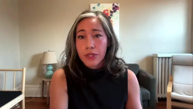 Naomi Lim wearing a black sleeveless top looks to camera