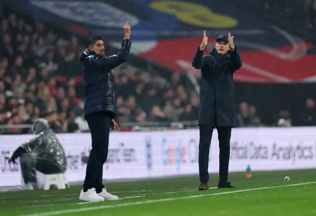 Thomas Tuchel, Head Coach of England, reacts alongside Veljko Paunovic,