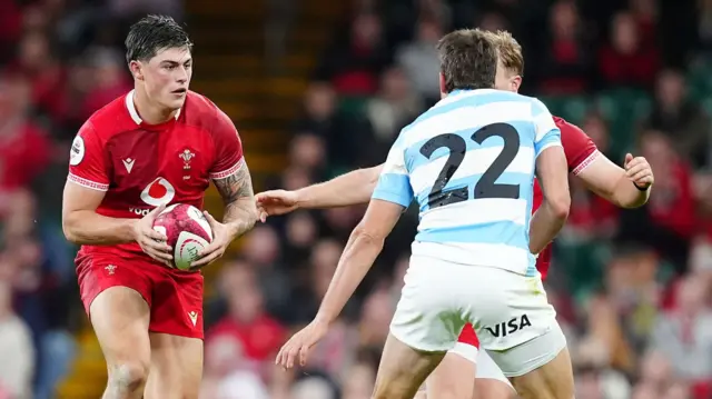 Louis Rees-Zammit carries the ball while playing for Wales