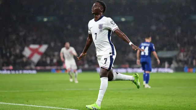 Bukayo Saka celebrates in the rain after scoring for England