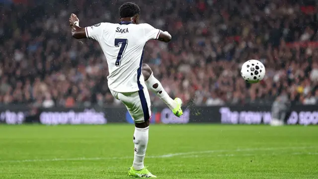 Bukayo Saka strikes the ball with his left foot.