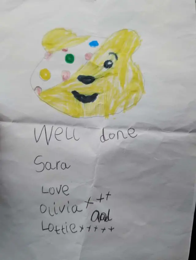 A drawing of Pudsey and text: "Well done Sara love Olivia and Lottie"