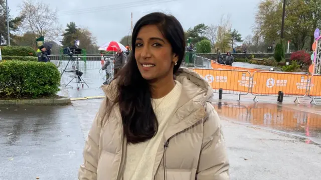 Tina Daheley in a cream puffer jacket on a rainy road