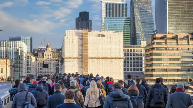 Commuters crossing London Bridge in the City of London