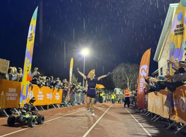 Sara Cox runs to a finish line