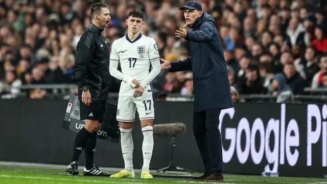 Phil Foden is given instructions by manager Thomas Tuchel before being brought on as a substitute.