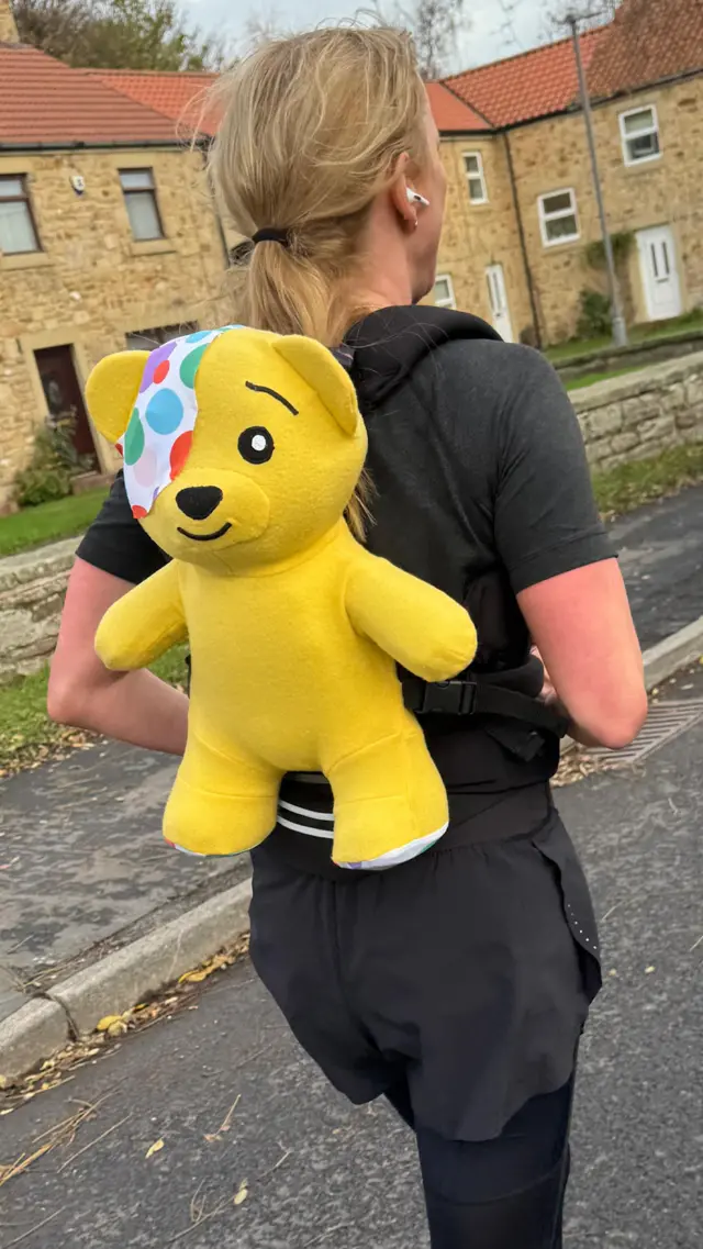 Sara on the move with Pudsey Bear on her back