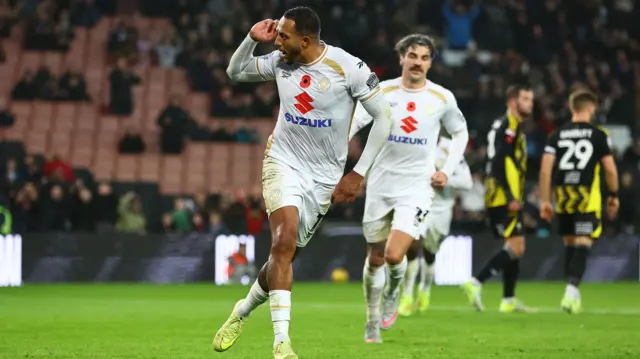 MK Dons' Nathaniel Mendez-Laing cups his ear in celebration