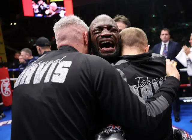 Ishmael Davis shouts and celebrates as he is hugged by his team