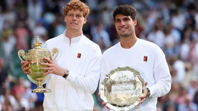 Sinner (left) and Alcaraz posing with the winner and runner-up trophies at Wimbledon