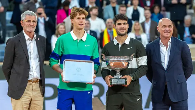 Sinner (second left) and Alcaraz (second right) with the runner-up and winner trophies at Roland Garros