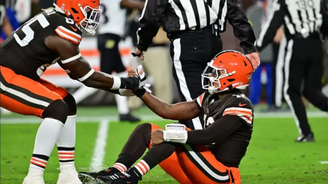 Cleveland Browns tight end David Njoku helps quarterback Shedeur Sanders to his feet after he threw an interception against the Baltimore Ravens
