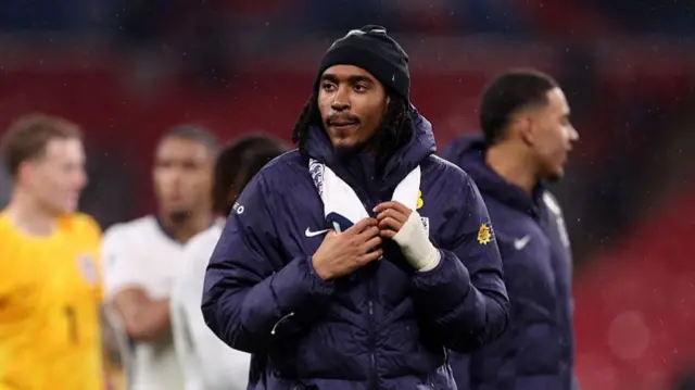 Djed Spence wearing a big England jacket.