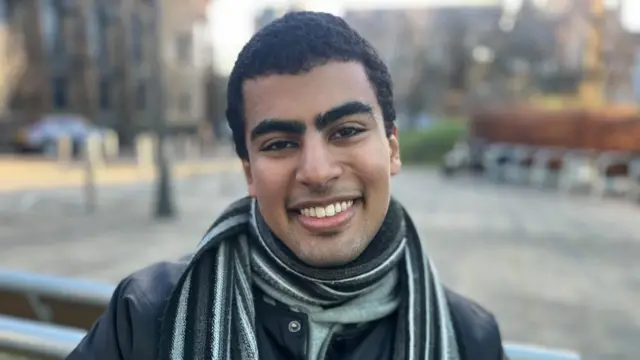 Motaz smiles to camera for a picture in the street