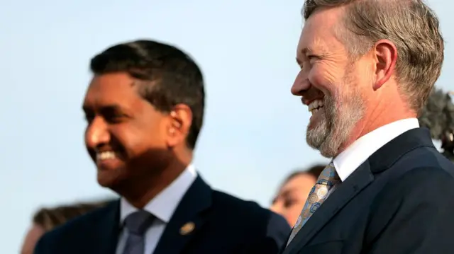 Ro Khanna and Thomas Massie, both in dark suits, smile
