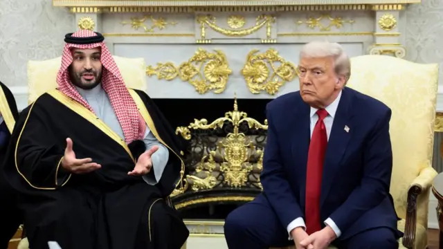 Mohammed bin Salman speaks while sat next to Trump, listening, at the Oval Office