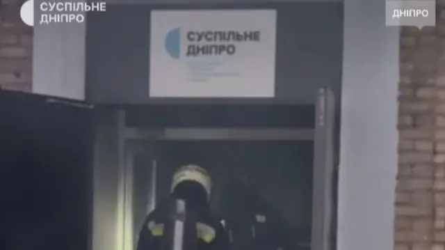 A screengrab from a video shared by Suspilne Dnipro showing firefighters entering its offices