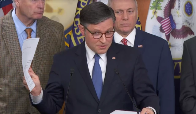 Mike Johnson is seen holding up papers