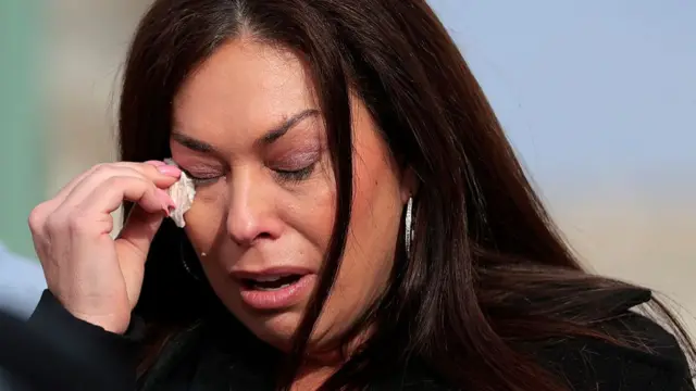 Haley Robson holding a tissue to her facve during the news conference in Washington DC