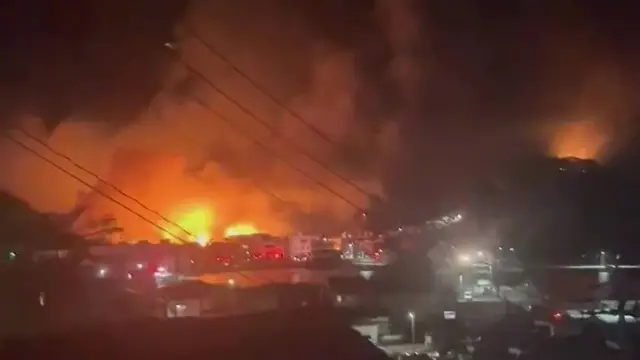 Video shows a fire breaking out in a residential area in southwestern Japan, with bright flames lighting up the night sky and thick smoke rising from it