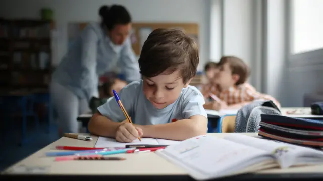 A child sits at a desk