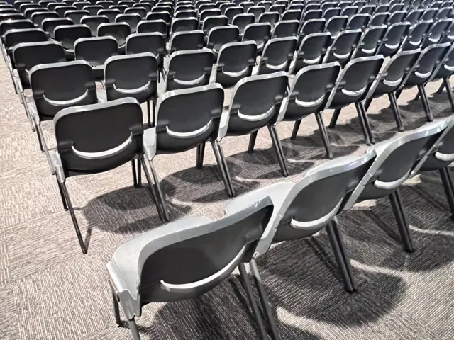 Rows of grey plastic chairs