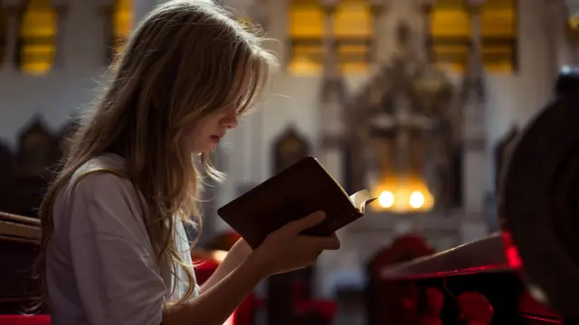 A child holds a bible in church