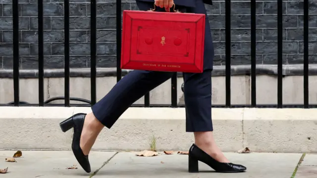 Rachel Reeves walks with the red budget box outside her office on Downing Street in London