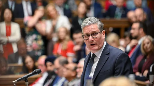 Starmer standing up in the Commons wearing a blue suit