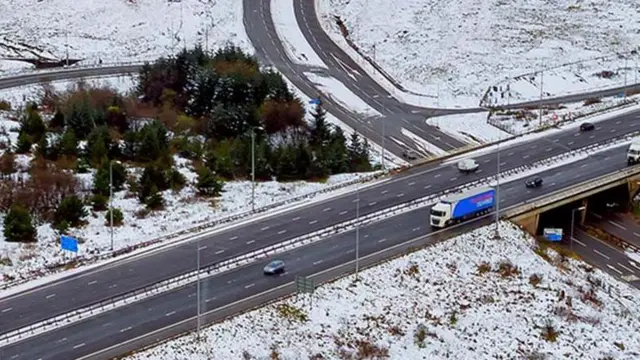 Aerial view on an A road that goes through some snowy land