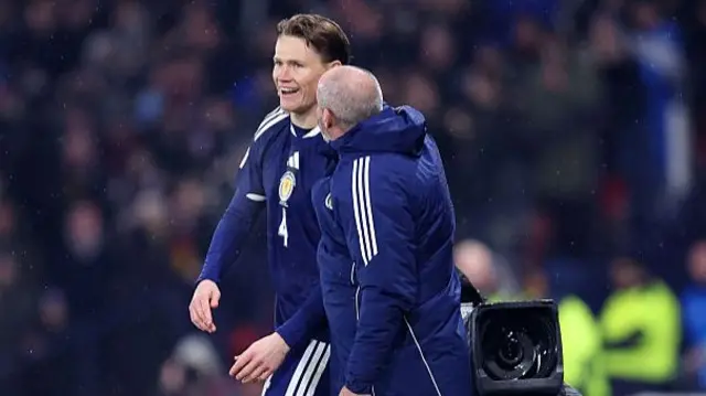 Scott McTominay smiling alongside manager Steve Clarke