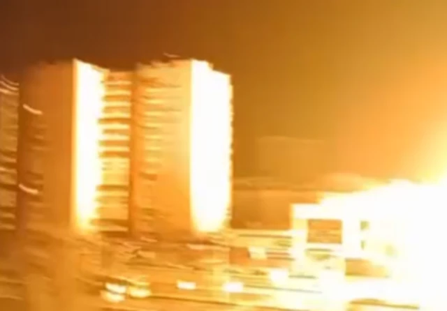 Two blocks of flats lit up by a flash of light