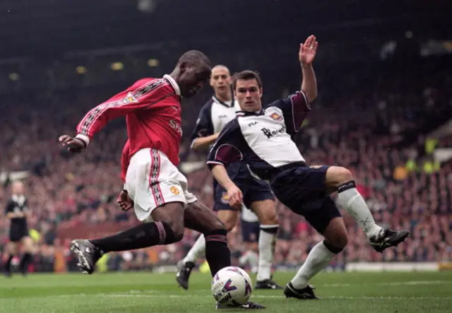 Andy Cole of Manchester United is challenged by Steve Potts of West Ham United during the FA Carling Premiership match at Old Trafford in Manchester, England