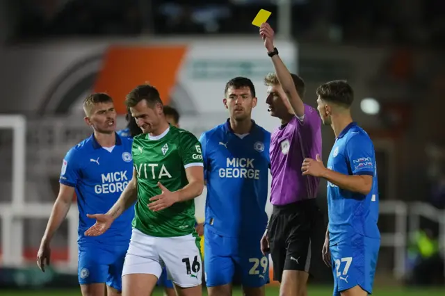 Callum Connolly of Stockport County is shown a yellow card