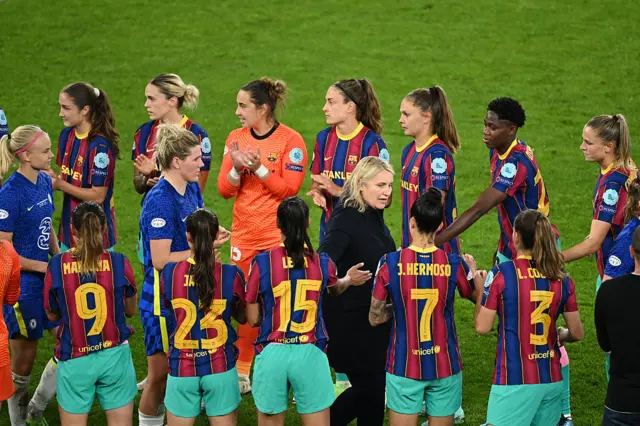 Emma Hayes (C-R) and Chelsea's players walk through Barcelona's players