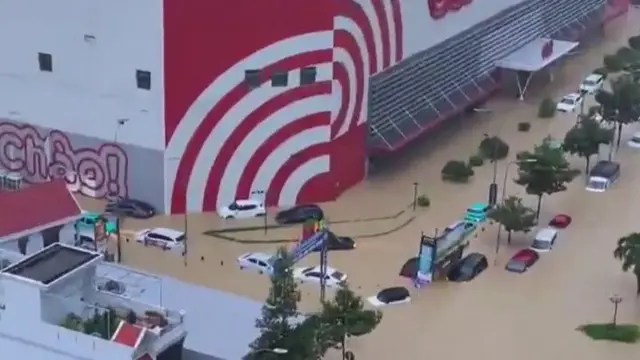 A flooded street is seen in one video with cars submerged up to their windows