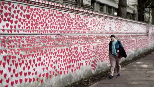 A member of the public by the National Covid Memorial Wall, a public mural painted by volunteers to commemorate the victims of the pandemic