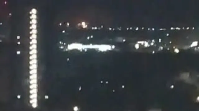 Night-time footage taken from an apartment balcony some miles away from the refinery shows a fire is burning