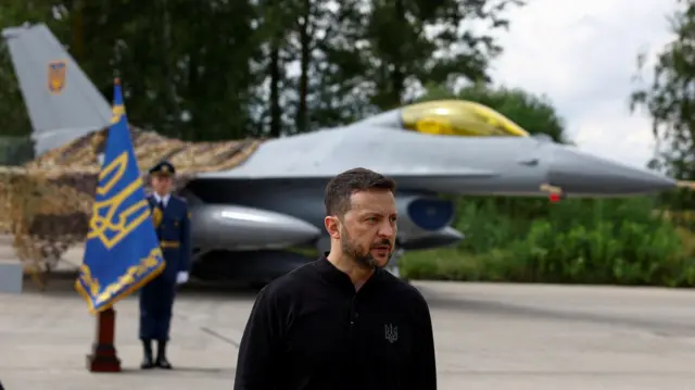 Ukraine's President Volodymyr Zelenskiy speaks to the media in a front of an F-16 fighter je