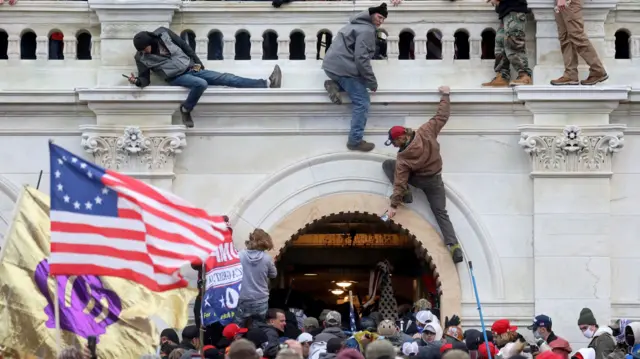 A mob of supporters of U.S. President Donald Trump fight with members of law enforcement at a door they broke open as they storm the U.S. Capitol Building in Washington