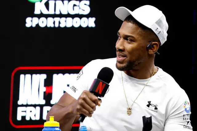 Anthony Joshua speaking into a microphone