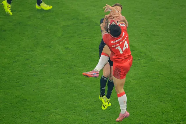 Louis Rees-Zammit challenges for the ball in the air