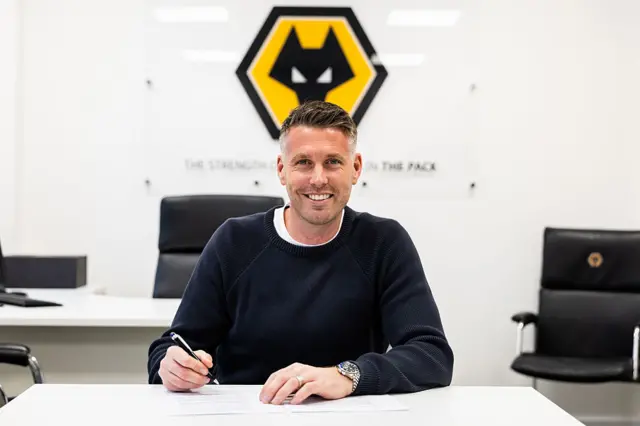 Wolves boss Rob Edwards signing his contract