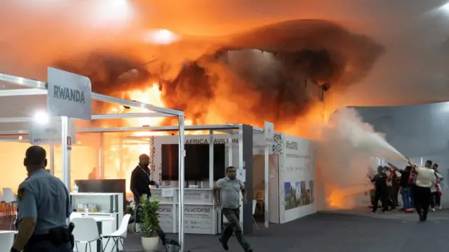 People use fire extinguishers to put out a fire at COP30.