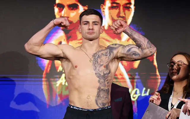 Sam Noakes is shirtless and holding his arms up