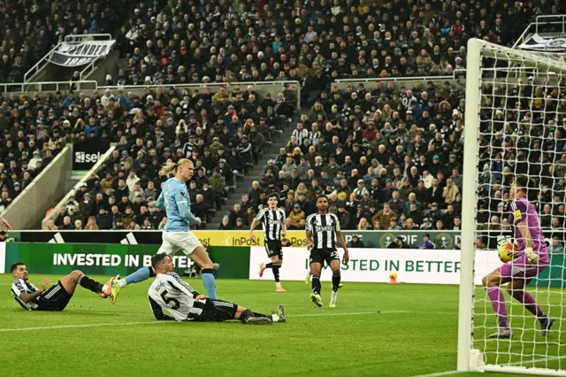 Newcastle United's English goalkeeper #01 Nick Pope (R) saves an attempt from Manchester City's Norwegian striker #09 Erling Haaland (2L) during the English Premier League football match between Newcastle United and Manchester City at St James' Park in Newcastle-upon-Tyne, north east England on November 22, 2025.